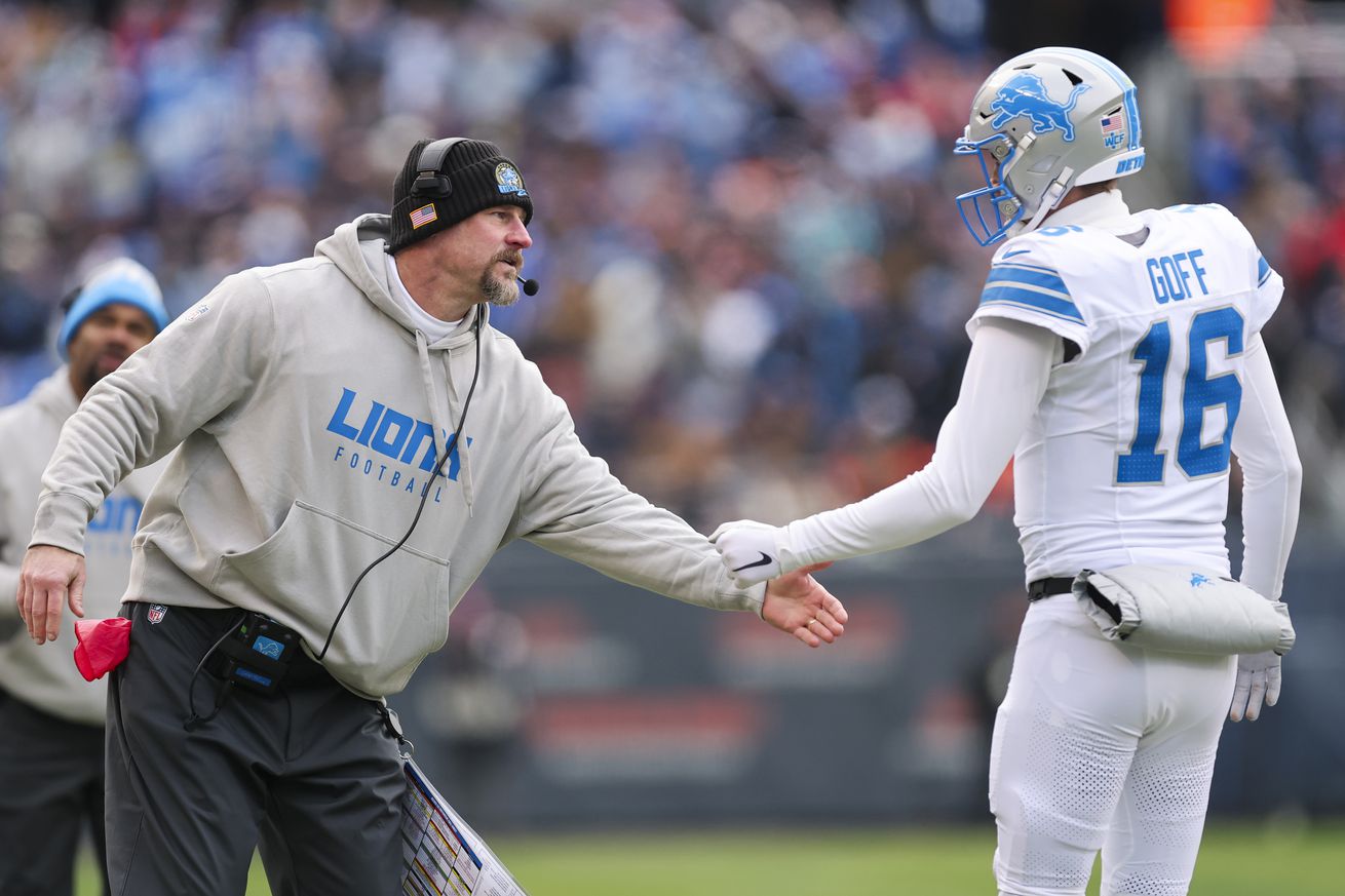 Head coach Dan Campbell of the Detroit Lions high fives Jared Goff #16 during the first quarter against the Chicago Bears at Soldier Field on December 22, 2024 in Chicago, Illinois.